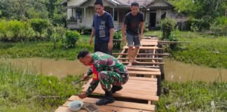 Bantu Kesulitan Rakyat, Babinsa Koramil 04/Jawai Bantu Warga Perbaiki Jembatan Penyeberangan Orang.